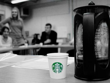 Starbucks cup present at an ACH meeting because they work for migrants and refugees