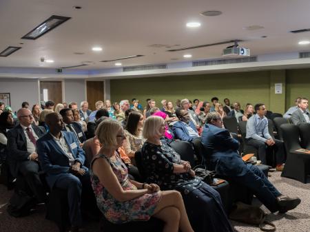 crowd at the ACH 10 year event where we spoke about refugees and migrants