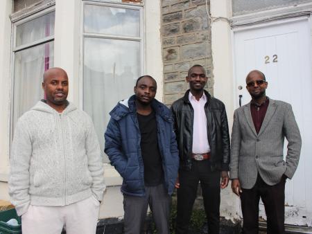 Refugees in front of a home funded by ethical investment