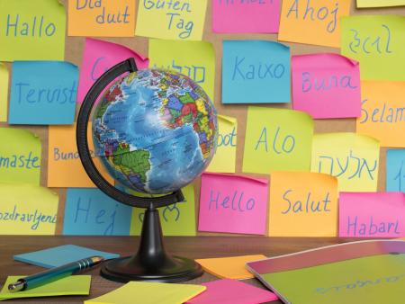 A globe in front of post it notes saying hello in multiple languages