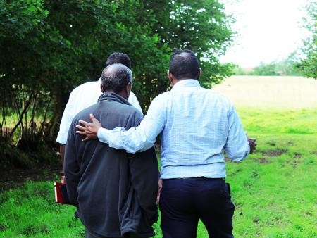 Refugee with arm around another refugee