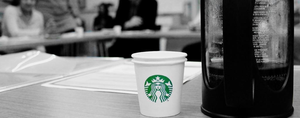 Starbucks cup present at an ACH meeting because they work for migrants and refugees