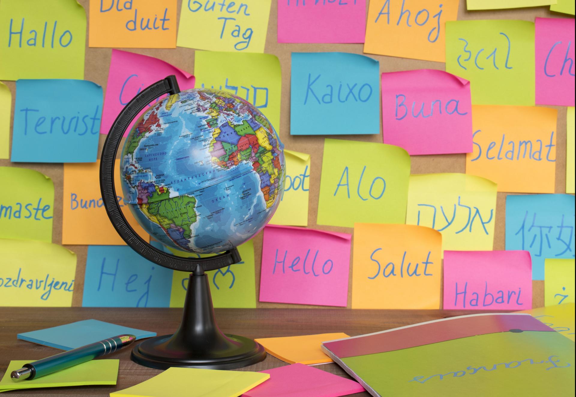 A globe in front of post it notes saying hello in multiple languages